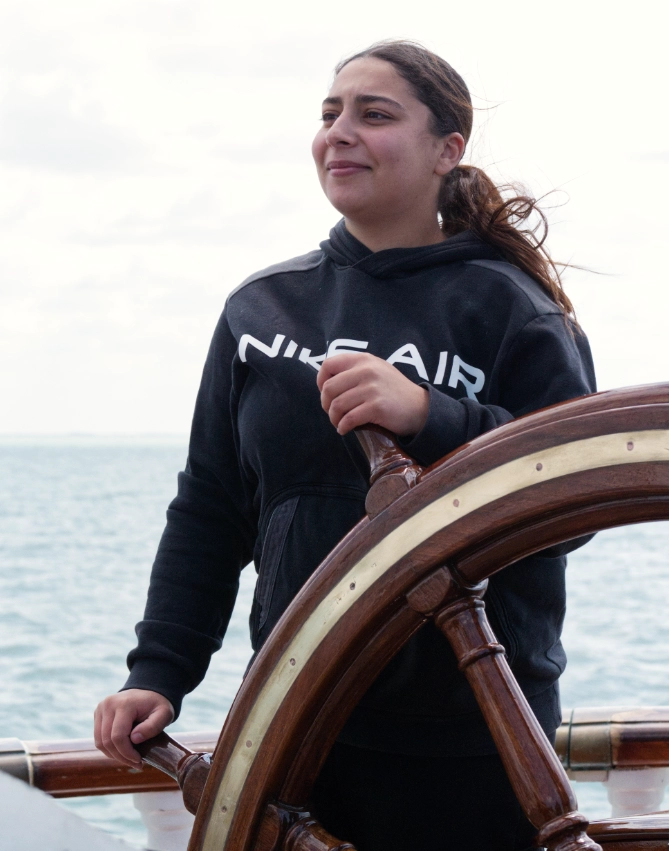 Une salariés de l'Académie Younus à la barre du Belem lors d'une sortie voile à La Rochelle.