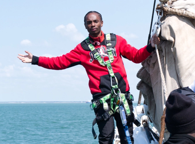 Un jeune de l'Académie Younus pose à la proue du Belem lors d'une sortie voile à La Rochelle.